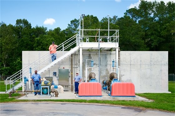 Wastewater treatment facility with workers standing by the tank